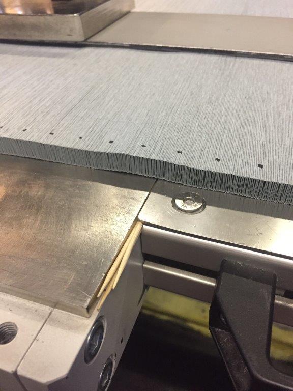 Grauer Materialstapel auf der Stanzmaschine mit Registriermarken